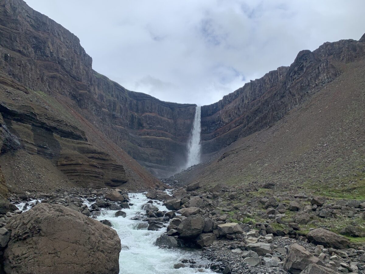 Vista della cascata Hengifoss: cosa vedere tra le pareti di basalto e gli strati rossi di argilla nell Islanda Orientale.
