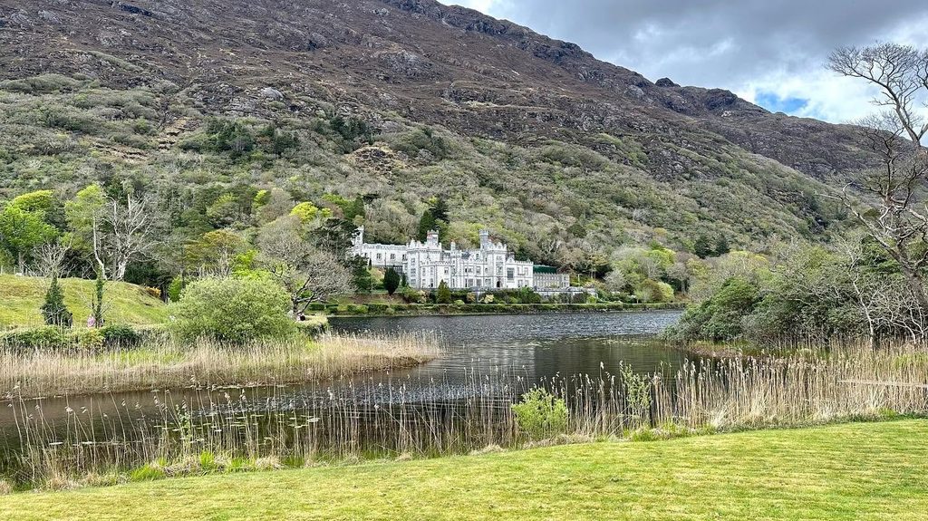 La facciata di kylemore abbey riflessa nelle acque del pollacapall lough nel connemara